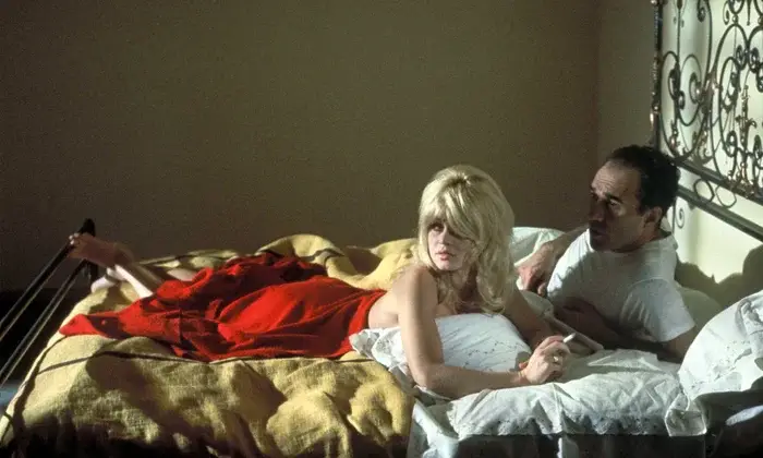 Two lovers lay on a bed looking in the same direction : Brigitte Bardot is smoking half naked after love showing a classic French love nonchalant scene