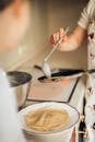 A mother and child cooking homemade crepes in the kitchen, creating family memories.
