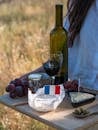 Relaxing outdoor picnic featuring French wine, cheese, and fresh grapes.
