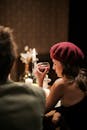 Elegant couple enjoying a candlelit dinner, woman in beret holding wine glass.