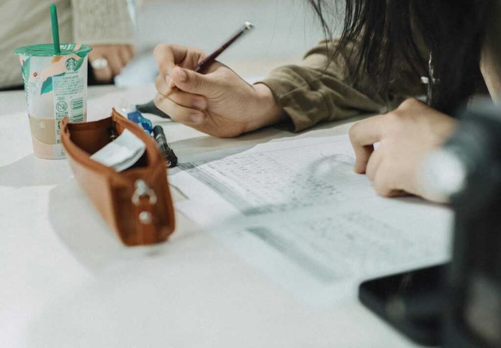 Apprenant travaillant son français dans un café ou une bibliothèque moderne à Singapour.