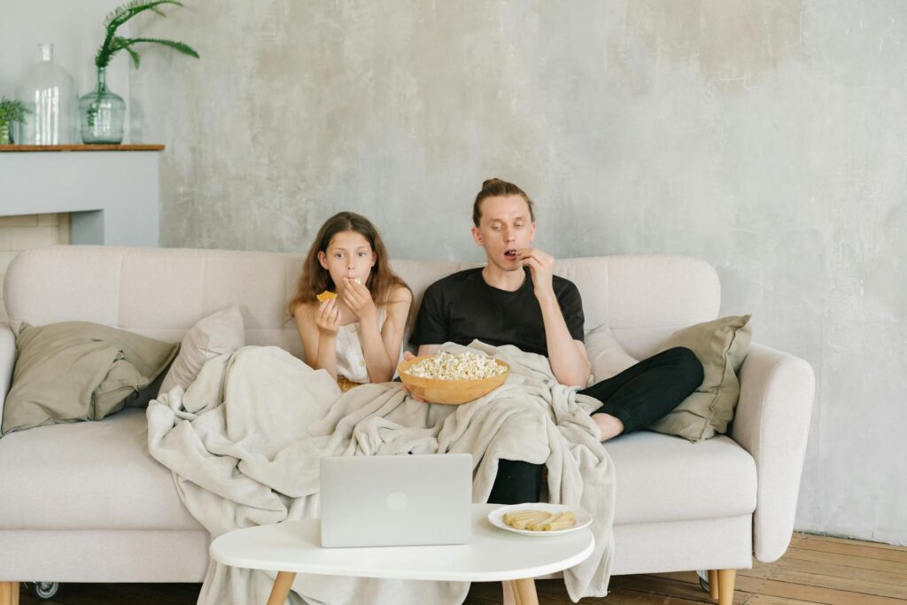 A cozy home movie night with subtitles and a notebook for learning French.