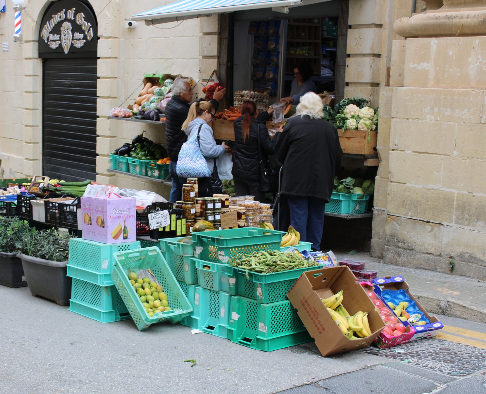 A customer speaking with a vendor at a colorful French market stall.