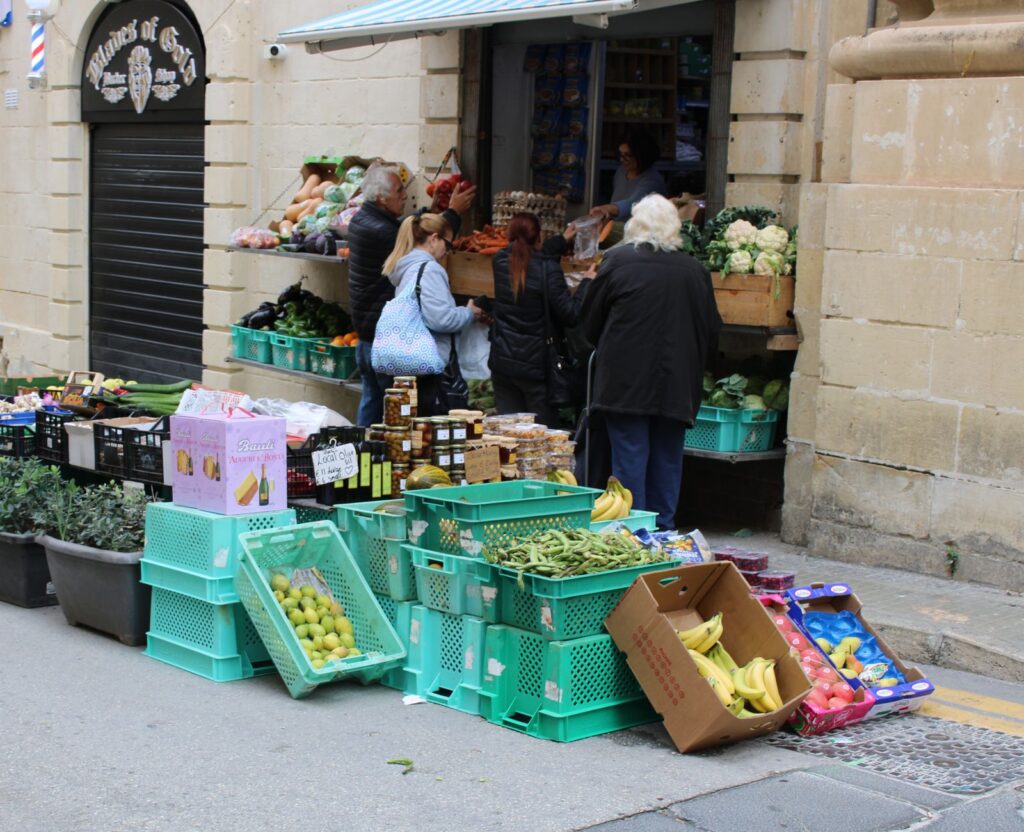 Client échangeant avec un vendeur devant un étal coloré de marché français.