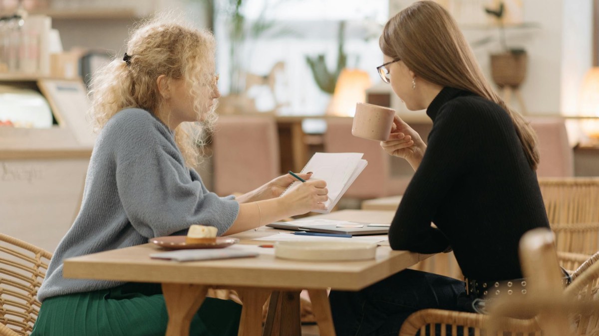 Adult learner practising French conversation calmly with notes.