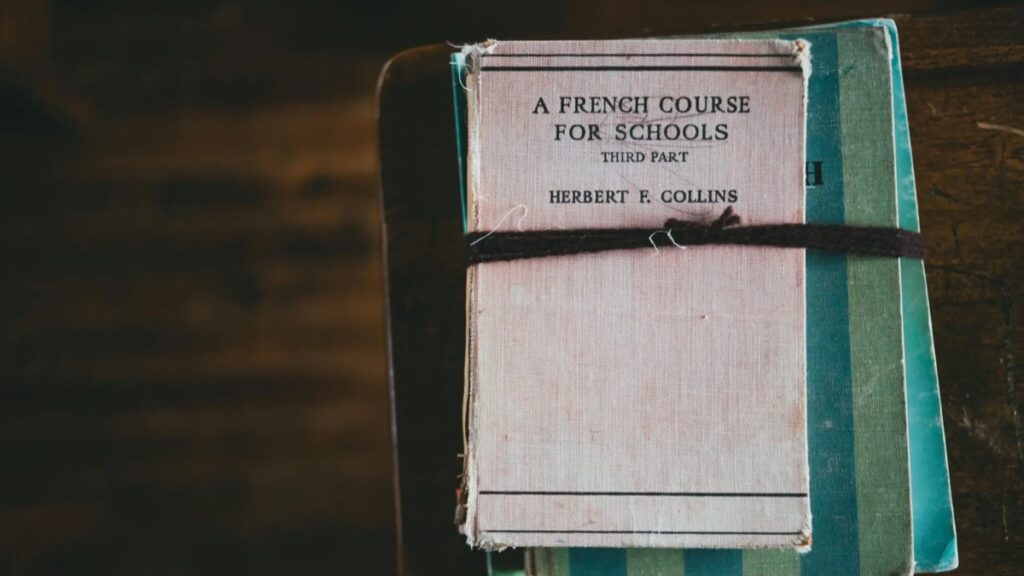 Parent préparant des documents d’inscription scolaire avec un cahier de français.