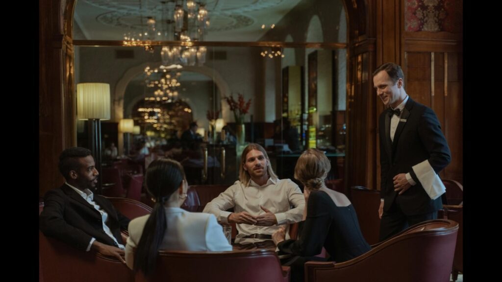 Professionals discussing business in a French hospitality setting.