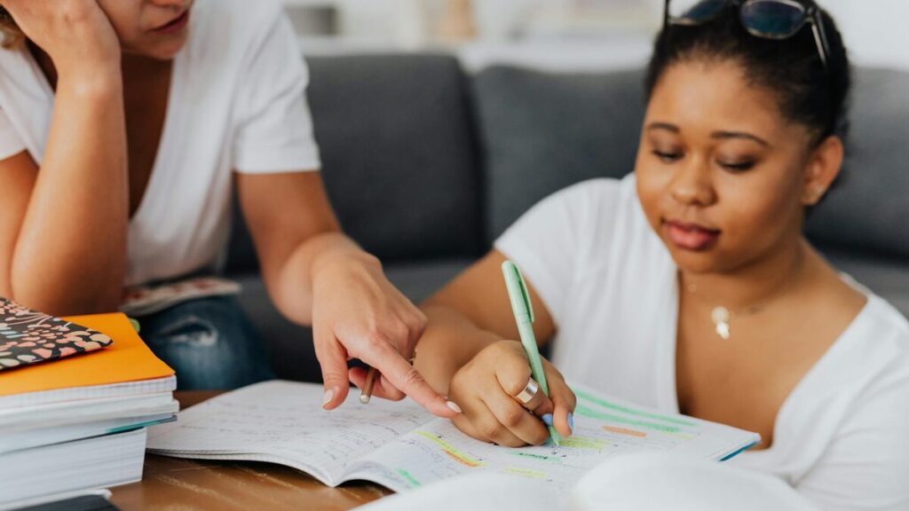 Adulte débutant qui apprend le français avec un carnet et du matériel d’étude sur une table