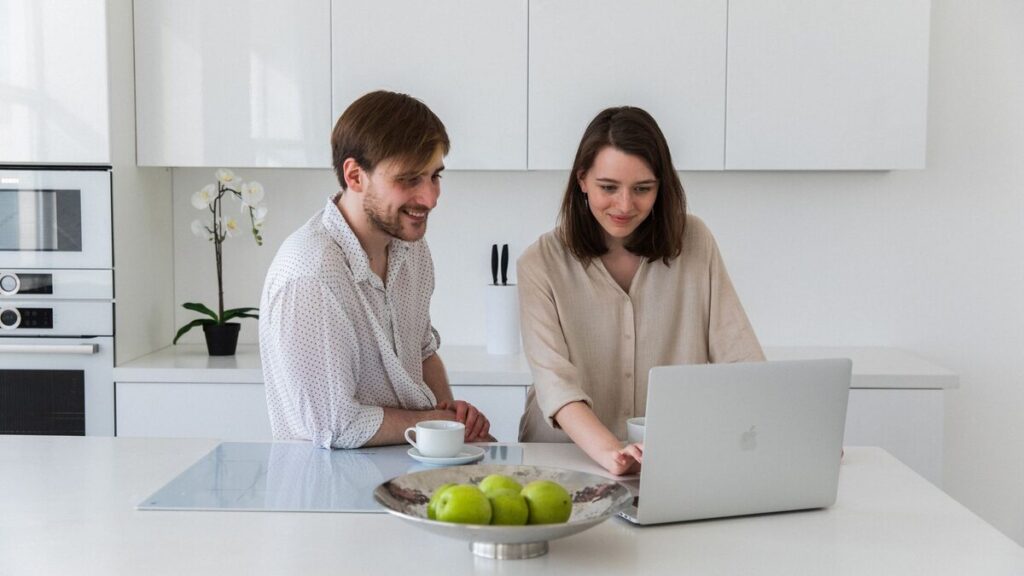 Adulte expatrié pratiquant une conversation en français en ligne à une table de cuisine