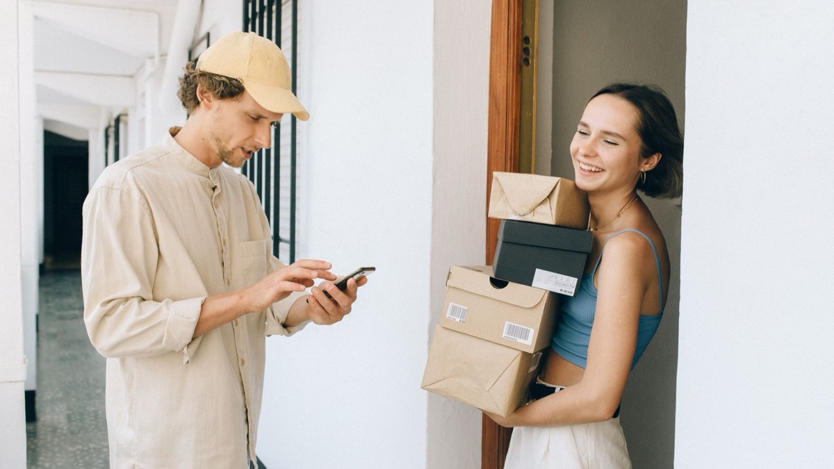 Adult learner answering a phone near a parcel at home
