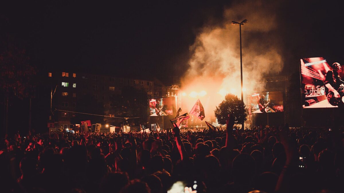 Adult festivalgoers watching a rock concert on a warm June evening in western France