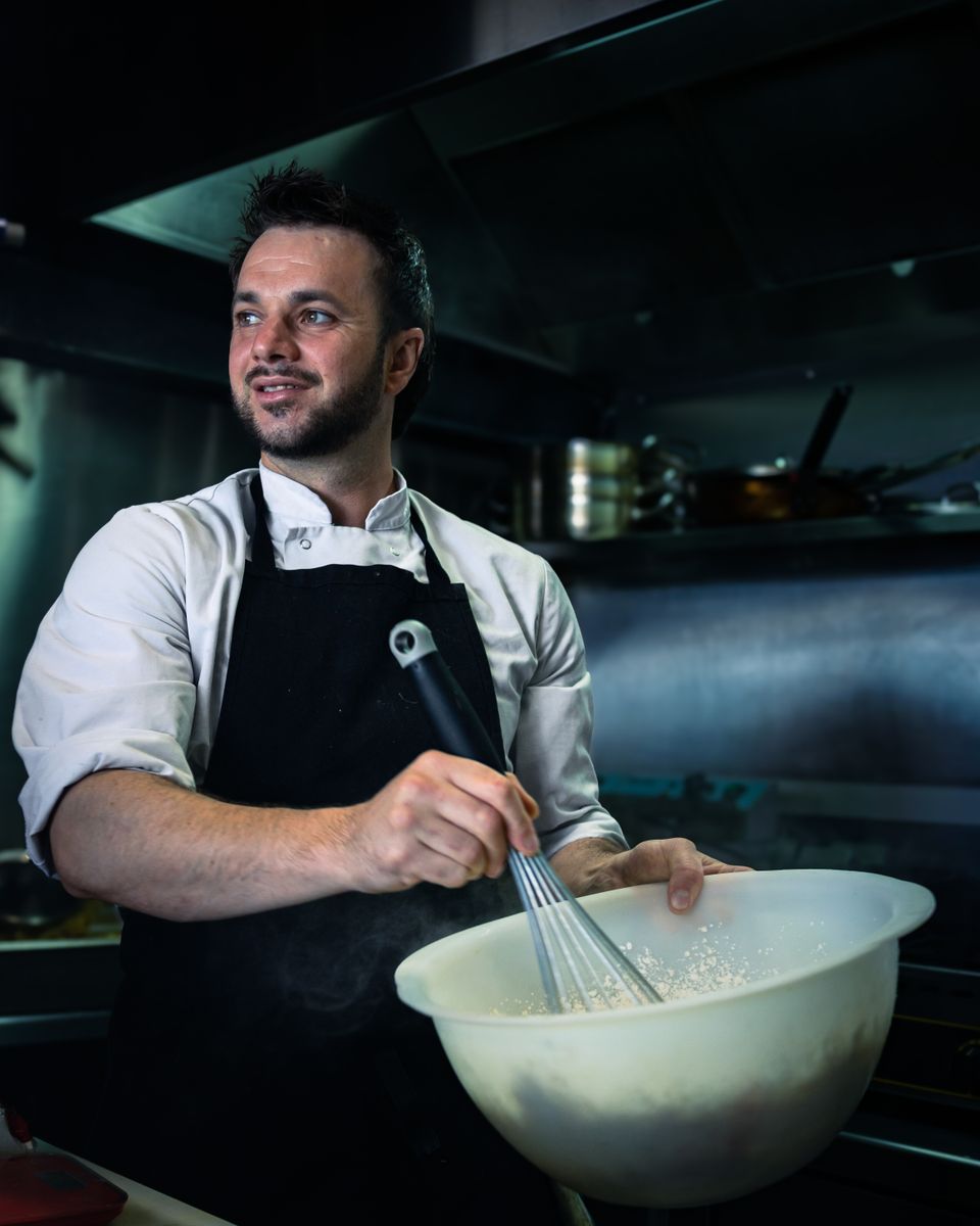 Chef whisking ingredients in a professional kitchen in Bayonne, France