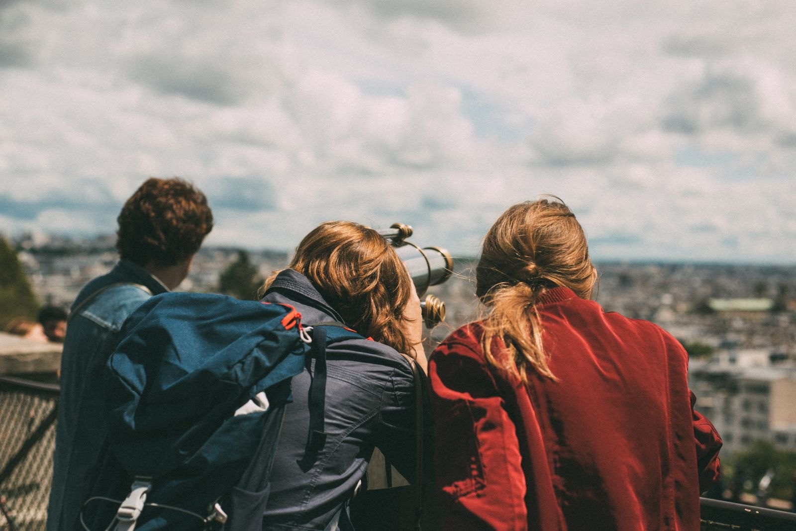 Visitors looking over Paris through a public viewing telescope