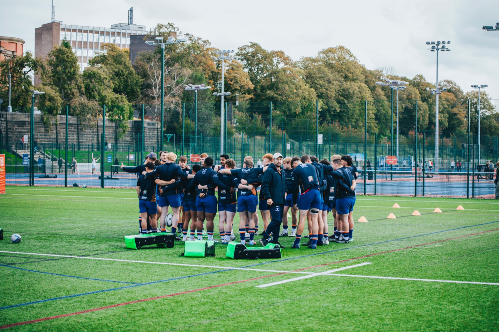 Rugby teammates huddling and talking during training